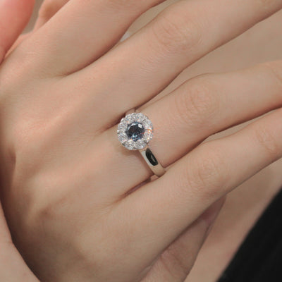 Close-up of a hand wearing a silver ring with a blue gemstone.