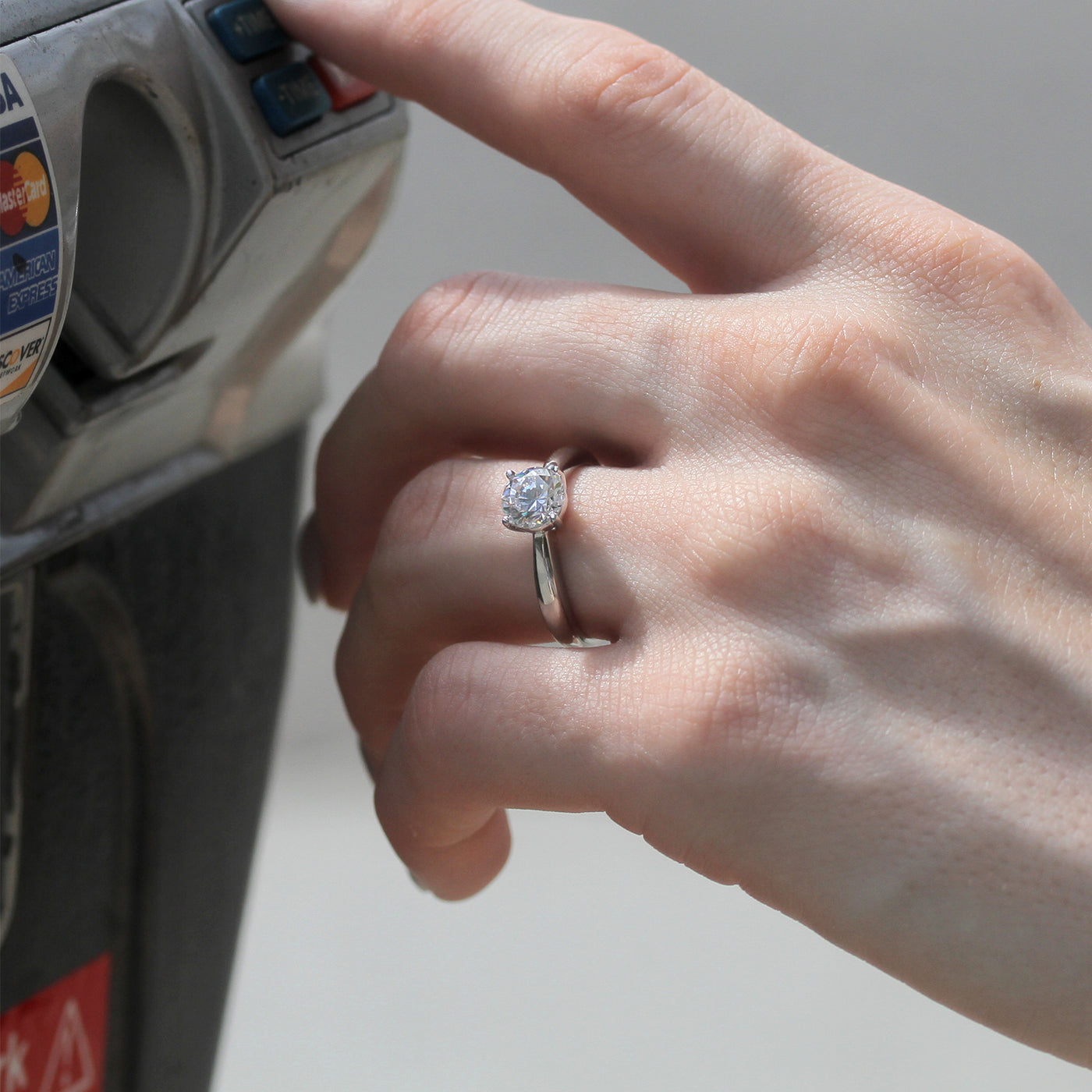 Hand wearing the Quiet Core Ring while  inserting a card into an ATM.