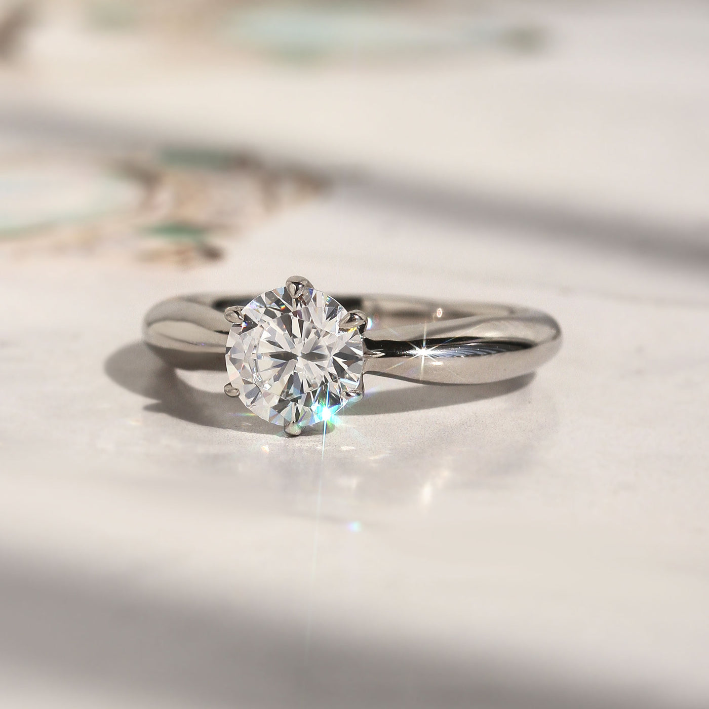 Side profile of solitaire ring showing 6-prong high setting and band taper