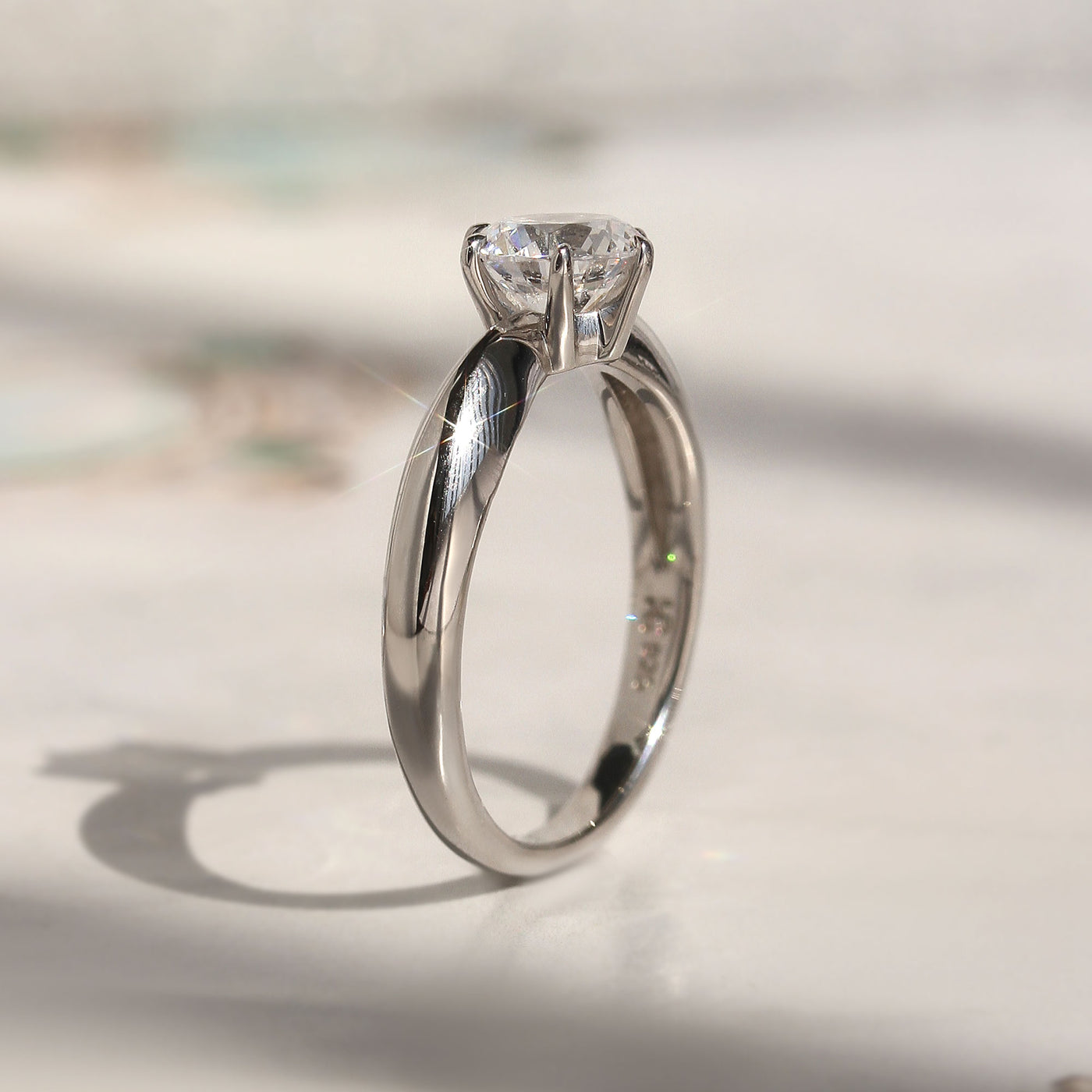 Side profile of solitaire ring showing 6-prong high setting and band taper