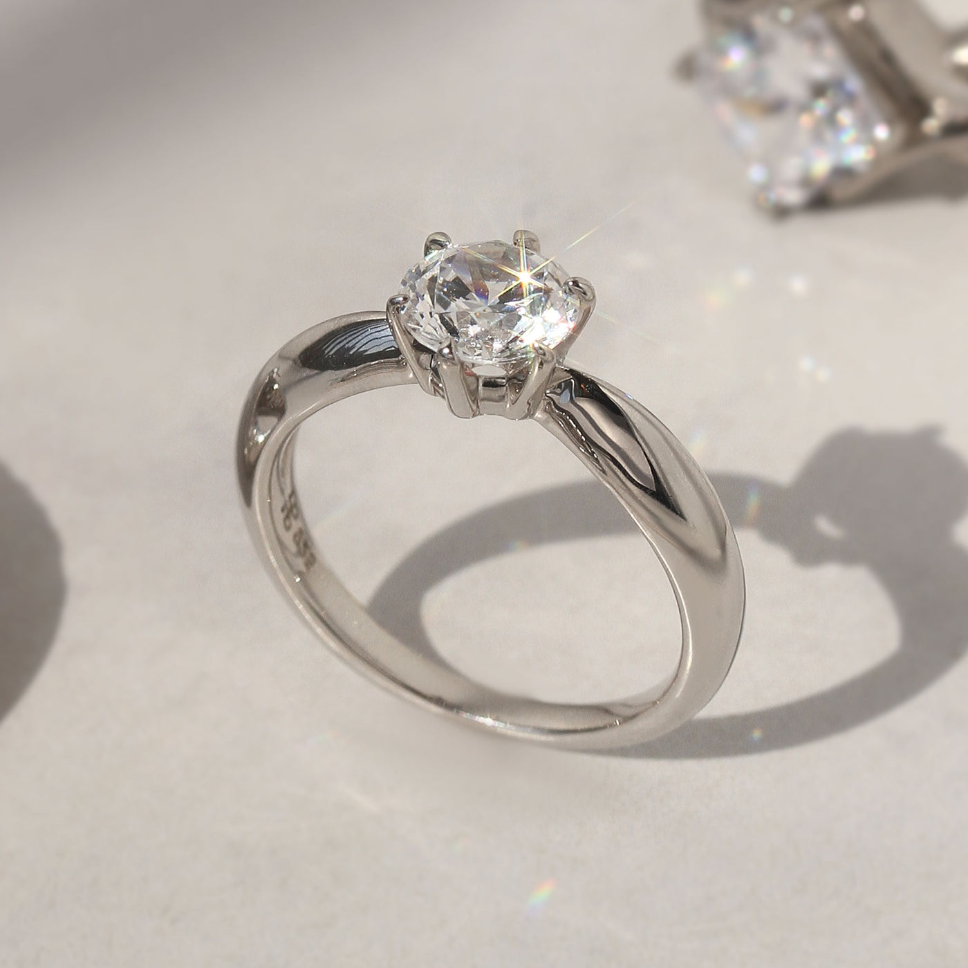 Side profile of solitaire ring showing 6-prong high setting and band taper