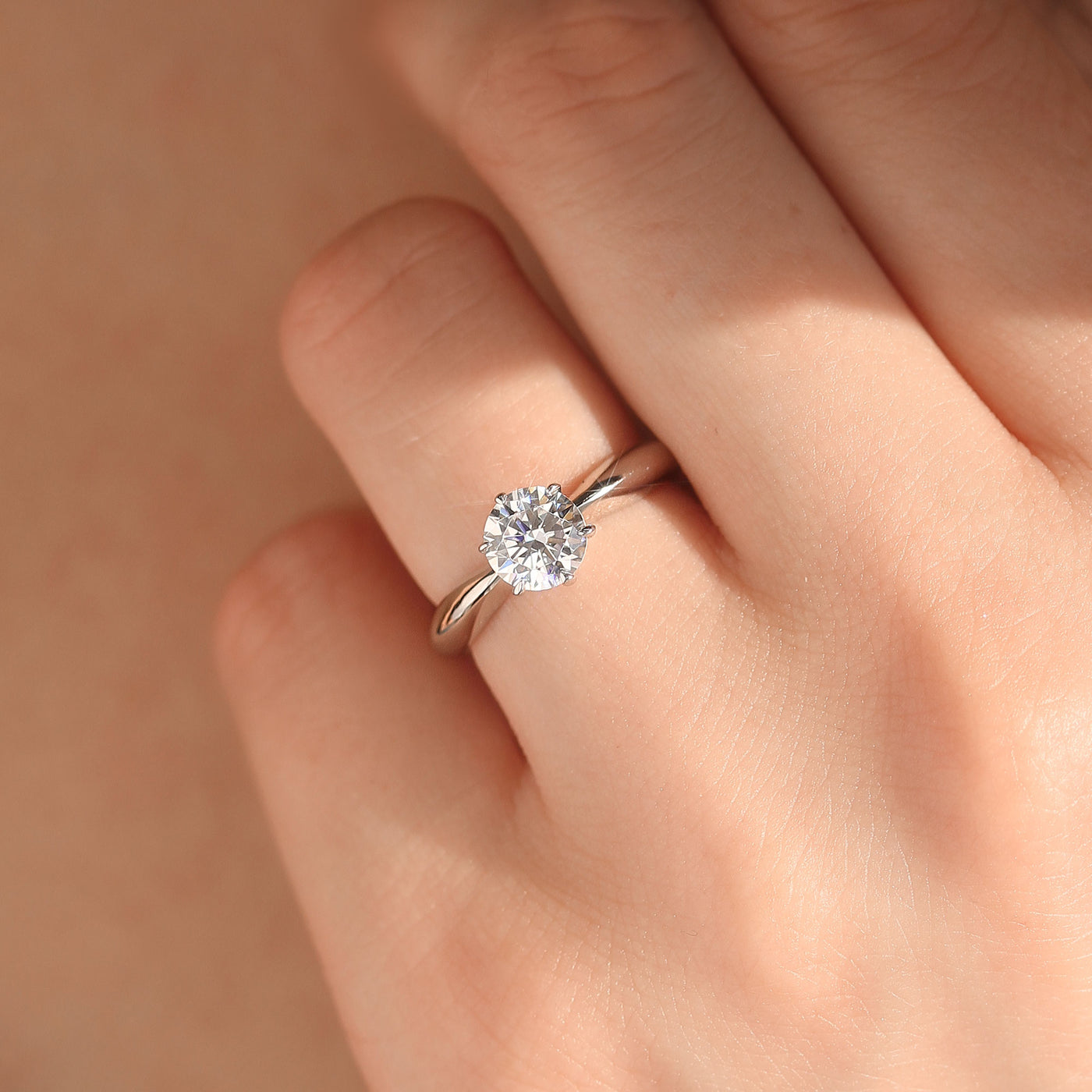 Close-up of a hand wearing the Still Worthy Solitaire Ring — a quiet, confident glow