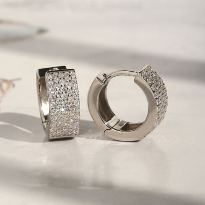Five-row pave huggie hoop earrings shown in close-up lighting