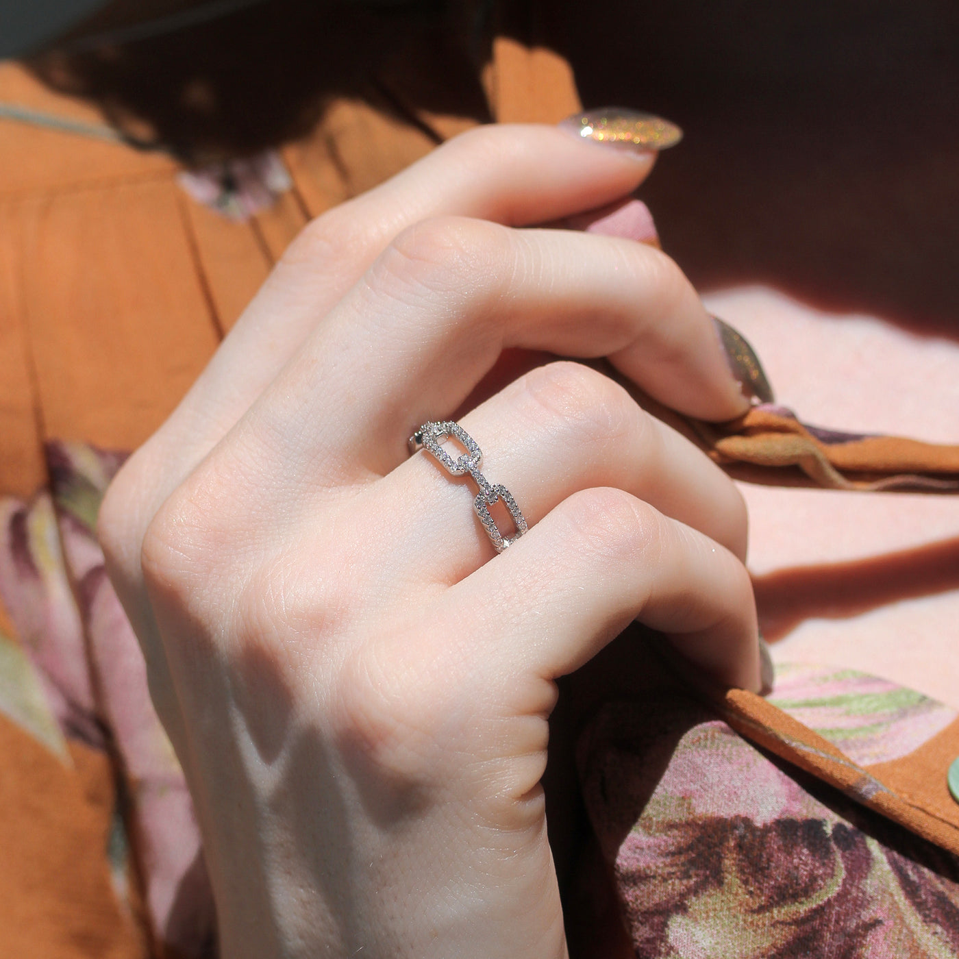 Close-up of a hand wearing a Sterling silver pavé-set chain-link eternity ring – Linklight Eternity Ring by Double Accent