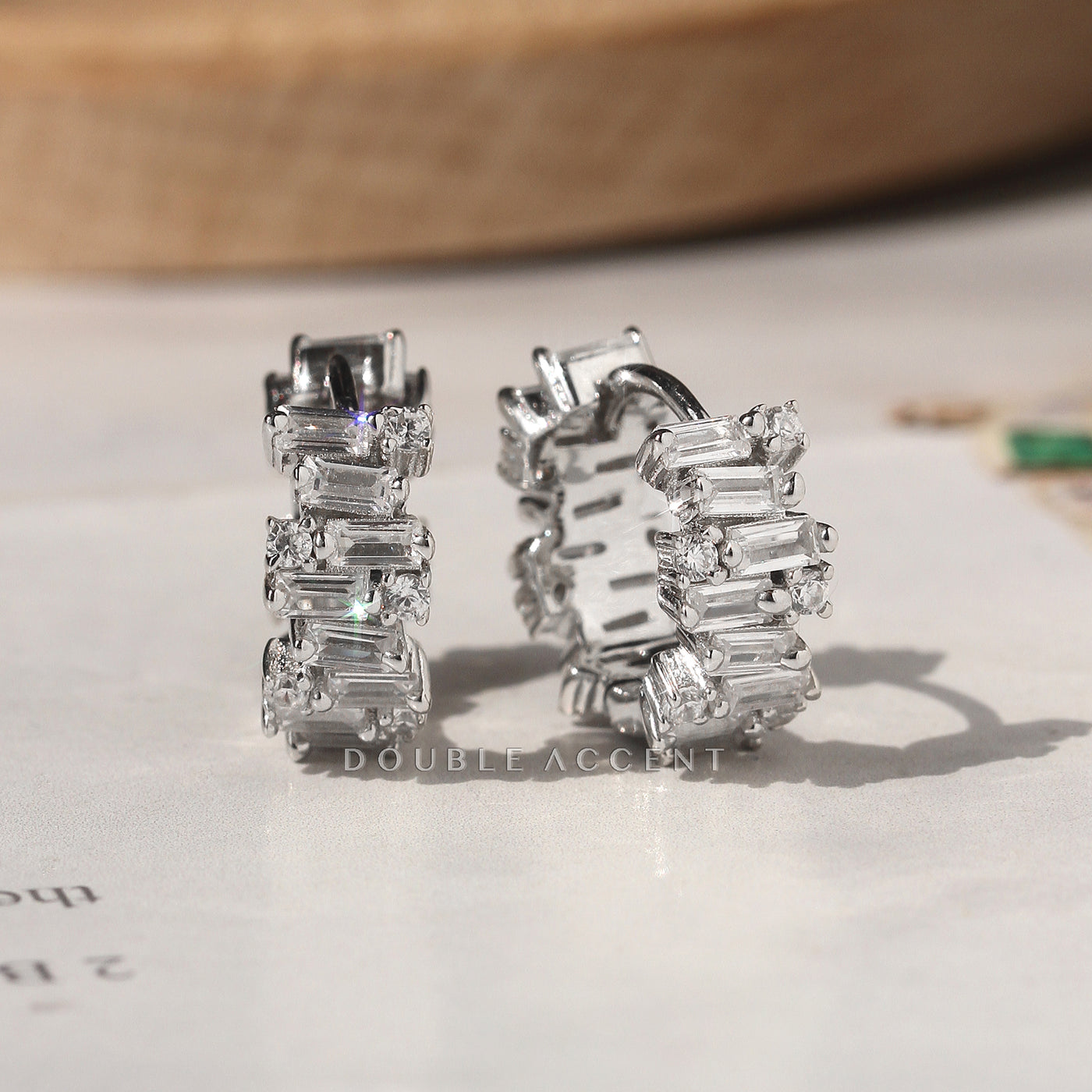 Baguette and round cubic zirconia huggie earrings close-up