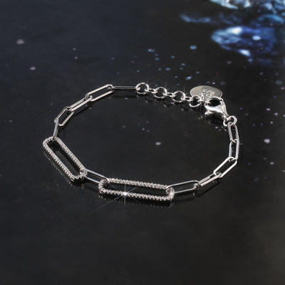 Silver bracelet with chain design on a dark reflective surface
