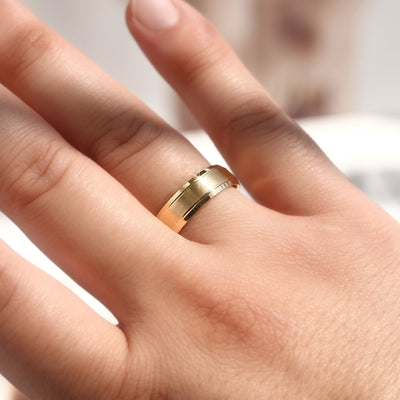 Gold ring on a person's finger with a blurred background