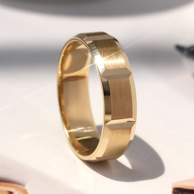 Gold ring with geometric design on a light background