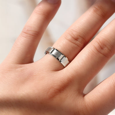 14K white gold ring on a person's finger against a neutral background