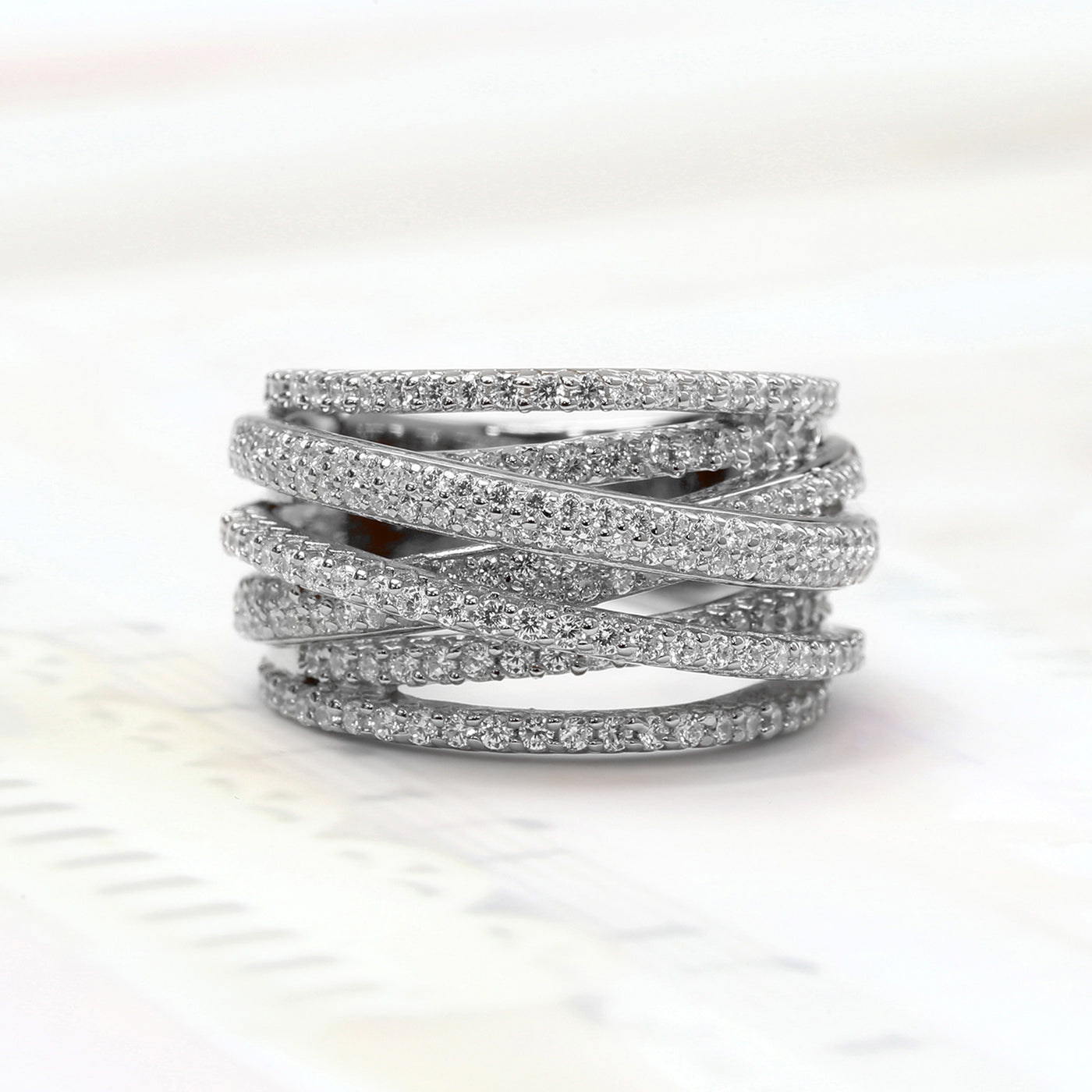 A close-up of Crosslight Ring – crisscross pave band in silver finishes symbolizing personal renewal.