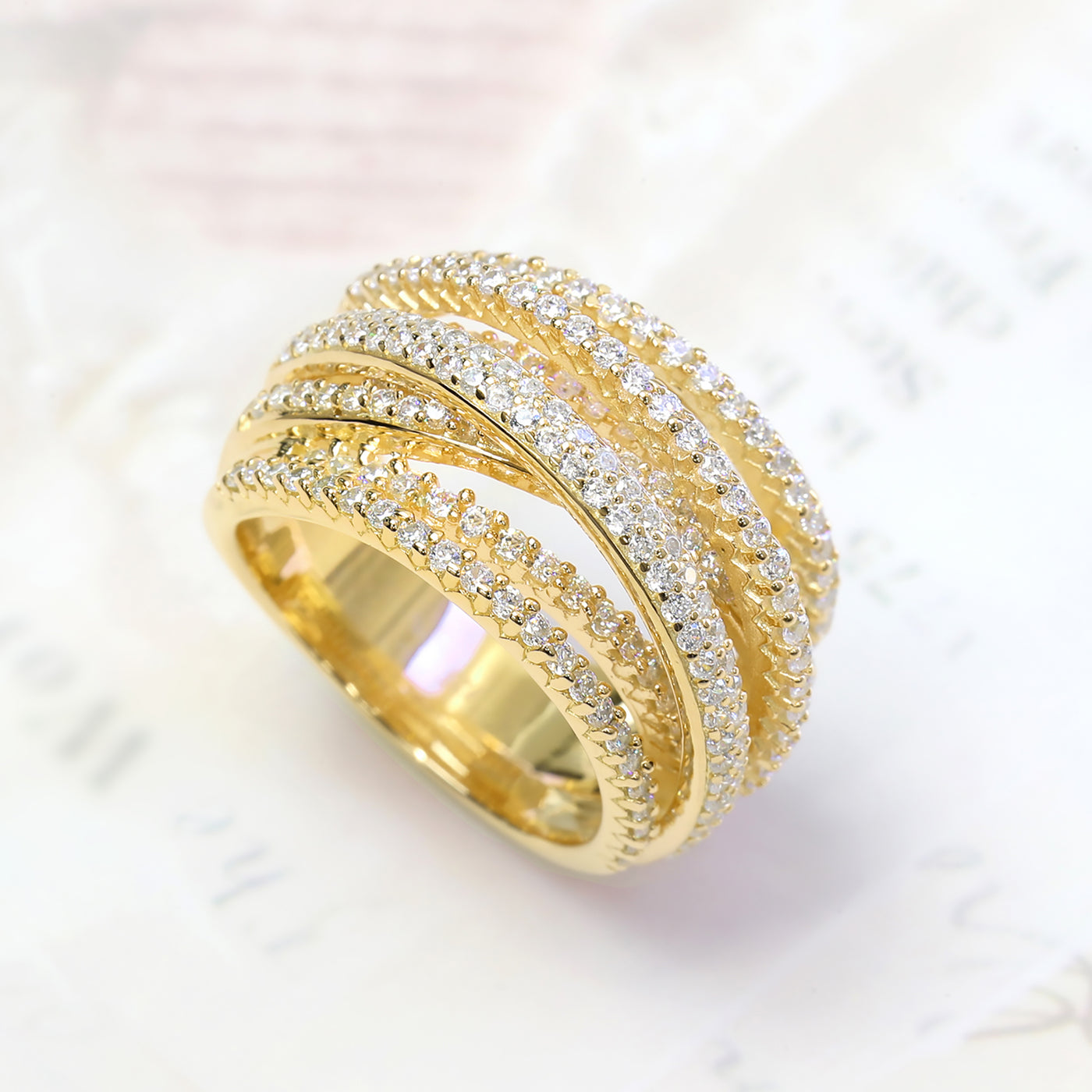 A close-up of Crosslight Ring – crisscross pave band in gold finishes symbolizing personal renewal.