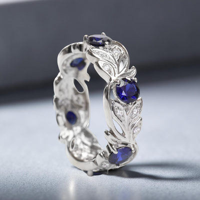 Evergrow Blue Ring – platinum-plated vintage vine eternity ring with simulated blue sapphire, symbolizing personal growth and timeless elegance.
