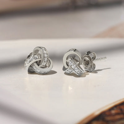 Promise Love Knot Stud Earrings in sterling silver with cubic zirconia stones, available in gold, rose gold, or rhodium finish.