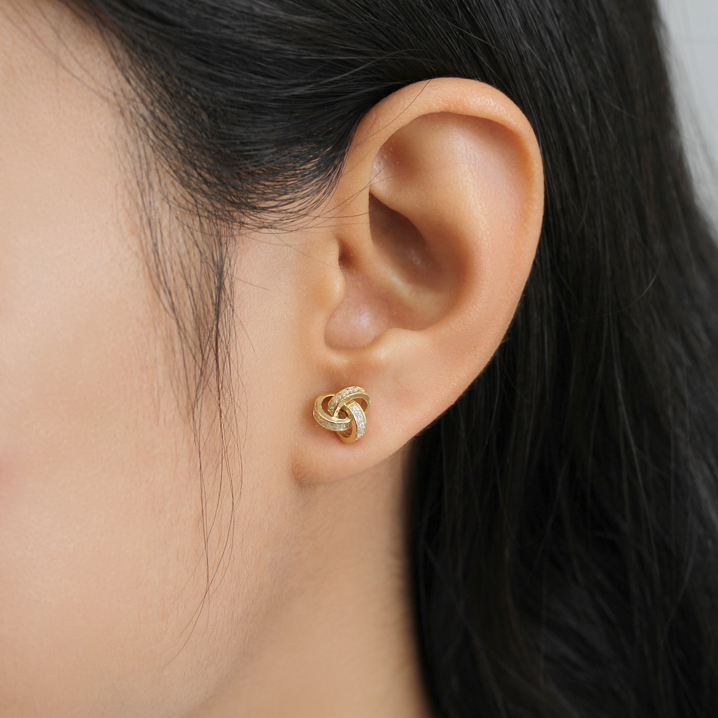 Promise Love Knot Stud Earrings in sterling silver with cubic zirconia stones, available in gold, rose gold, or rhodium finish.
