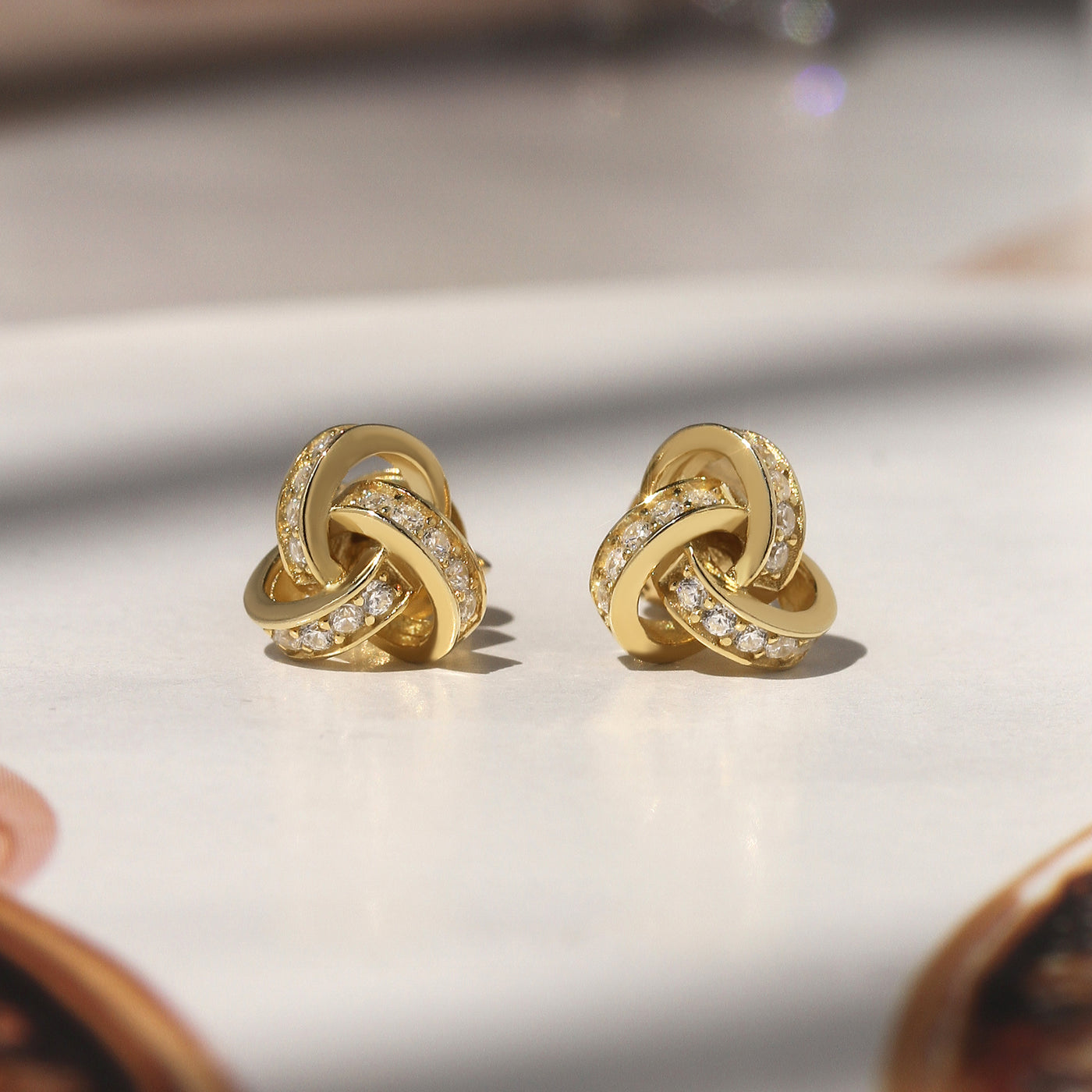 Promise Love Knot Stud Earrings in sterling silver with cubic zirconia stones, available in gold, rose gold, or rhodium finish.