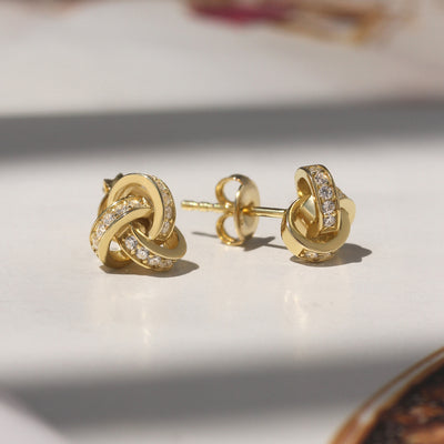 Promise Love Knot Stud Earrings in sterling silver with cubic zirconia stones, available in gold, rose gold, or rhodium finish.