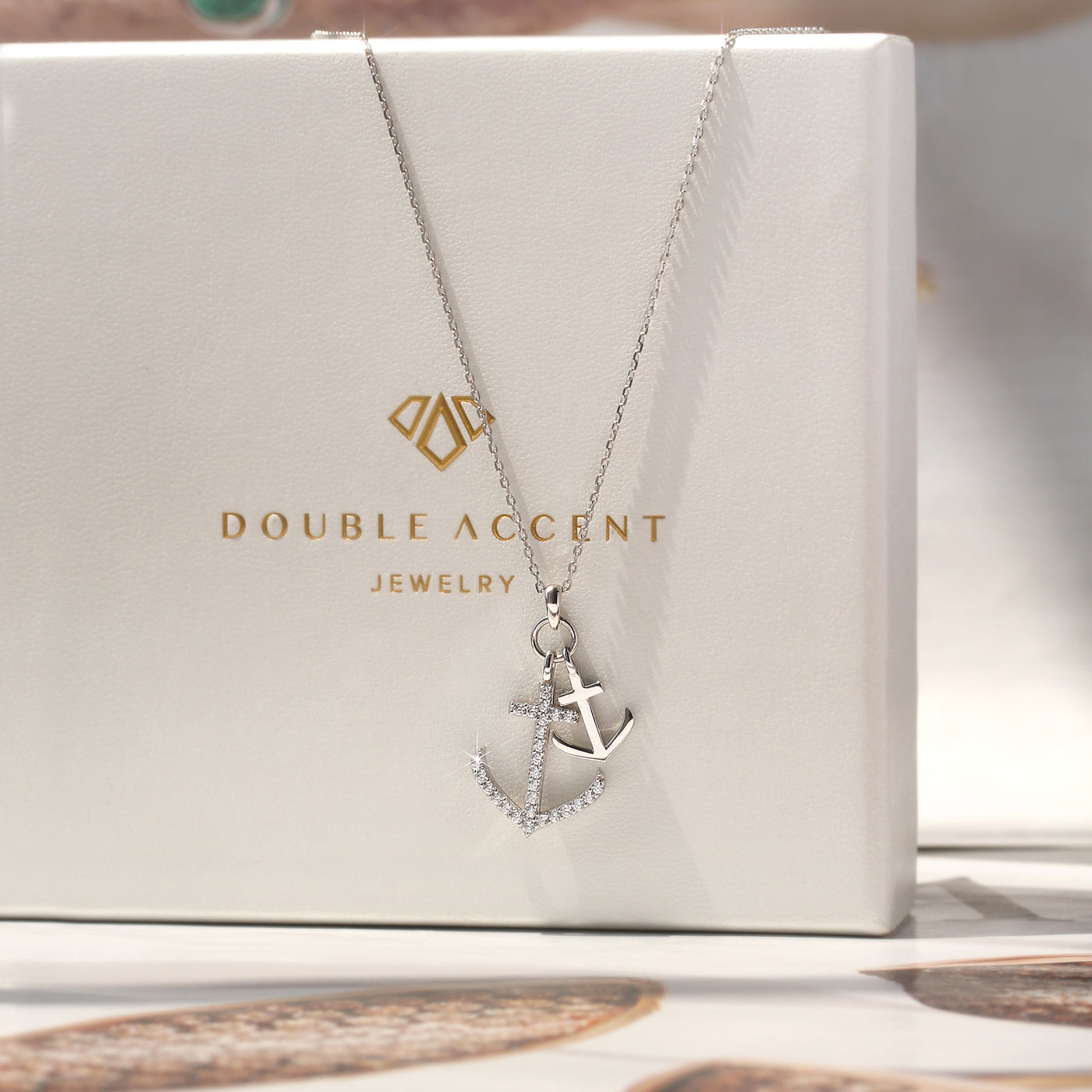 Silver necklace with an anchor pendant on a Double Accent Jewelry box.