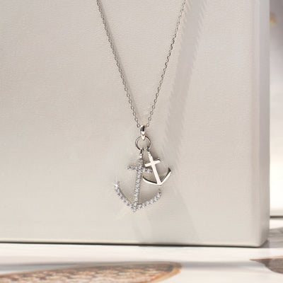 Silver necklace with an anchor pendant on a white surface