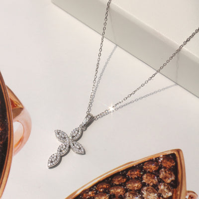 Platinum-plated sterling silver cross necklace with marquise and round cubic zirconia in an infinity-style design.