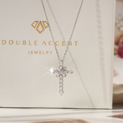 Silver cross necklace with sparkling stones on a Double Accent Jewelry box.