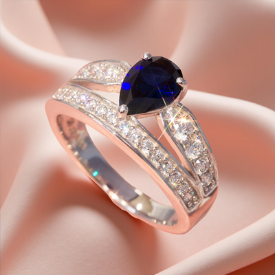 Silver ring with a blue gemstone on a soft pink background
