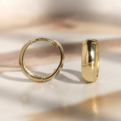 Close-up of dome-finished 14K gold huggie with click closure