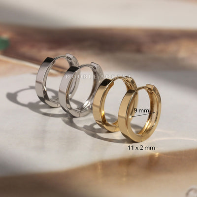 Two pairs of hoop earrings, one silver and one gold, on a light surface with 'Double Accent' branding.