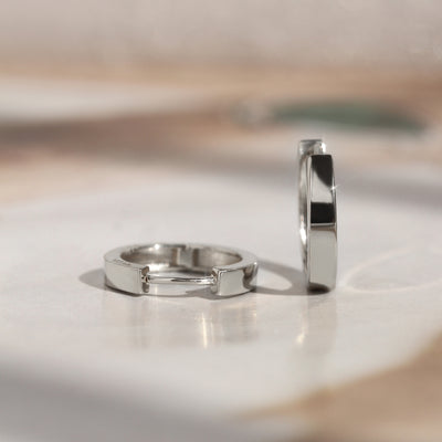 White gold First Shine Huggie Hoops softly lit for texture detail