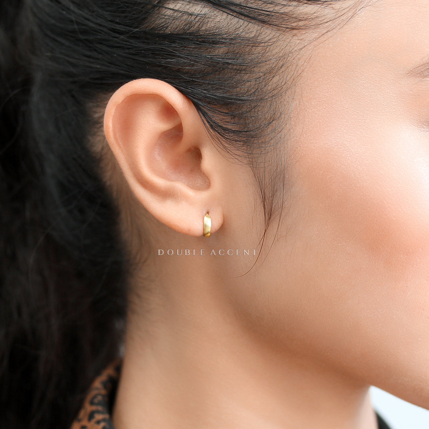 Dome huggie earrings worn close to the earlobe for a minimal look