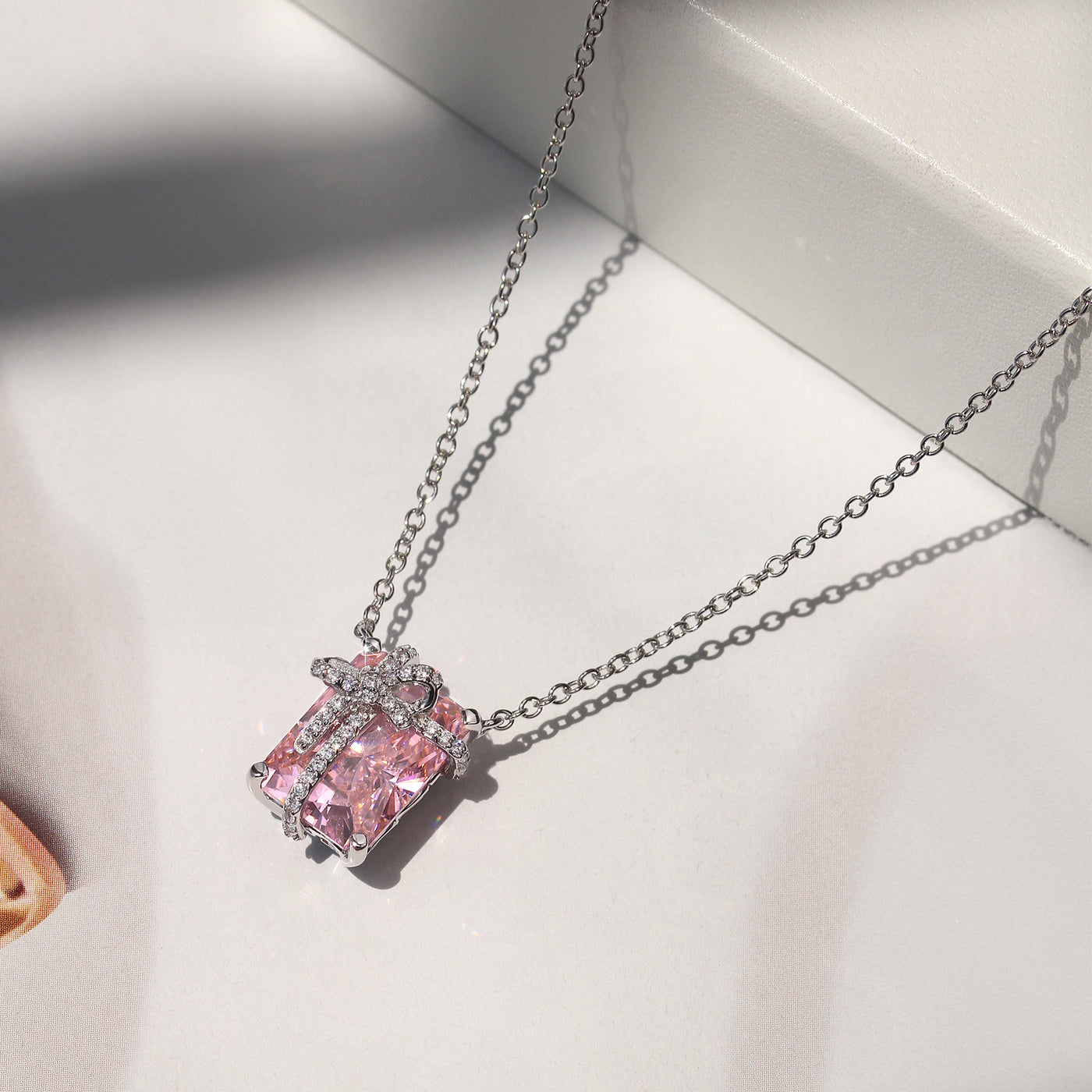 Blush Gift Pendant — sterling silver necklace with pink diamond-tone CZ and ribbon-like detail, gift-ready presentation