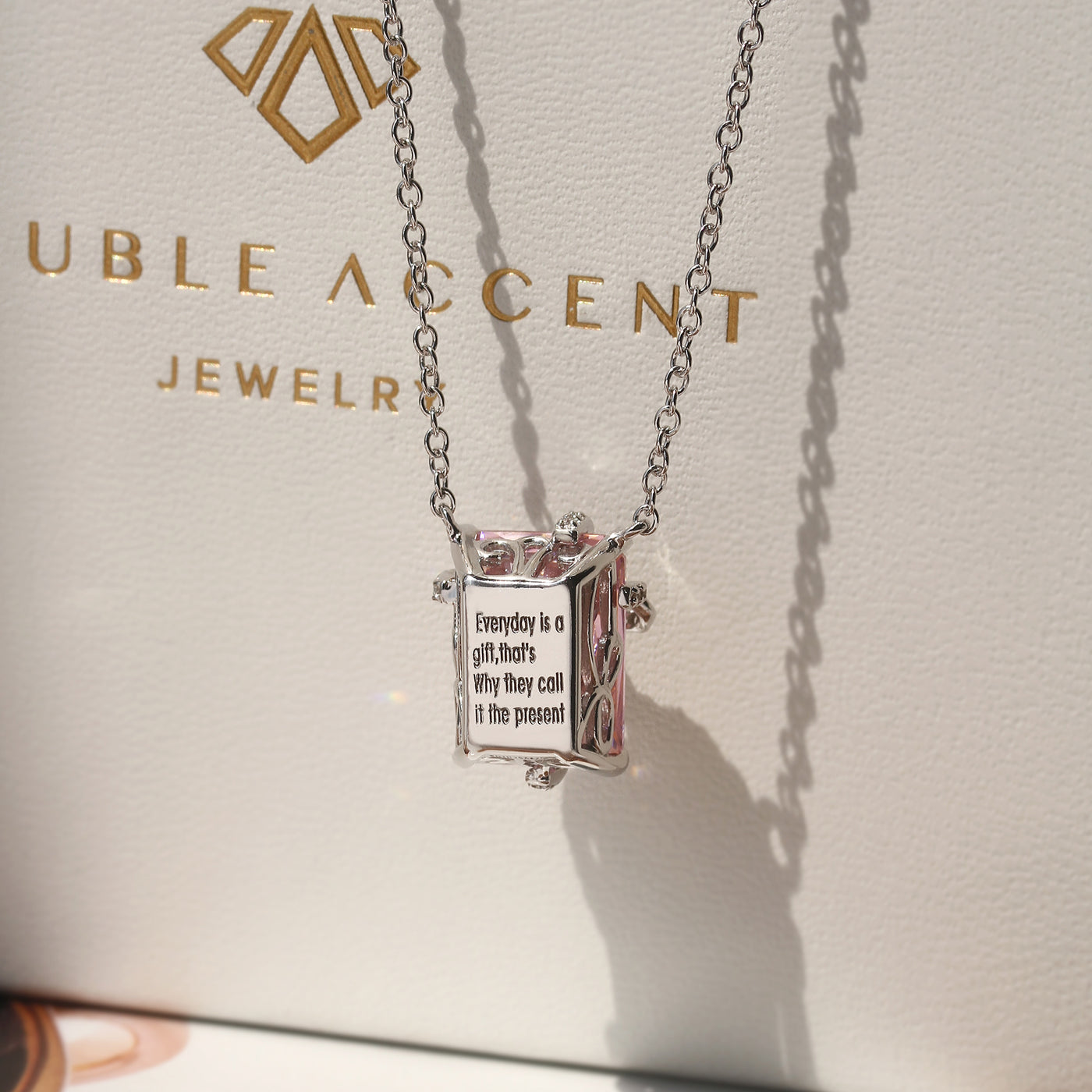 Blush Gift Pendant — sterling silver necklace with pink diamond-tone CZ and ribbon-like detail, gift-ready presentation