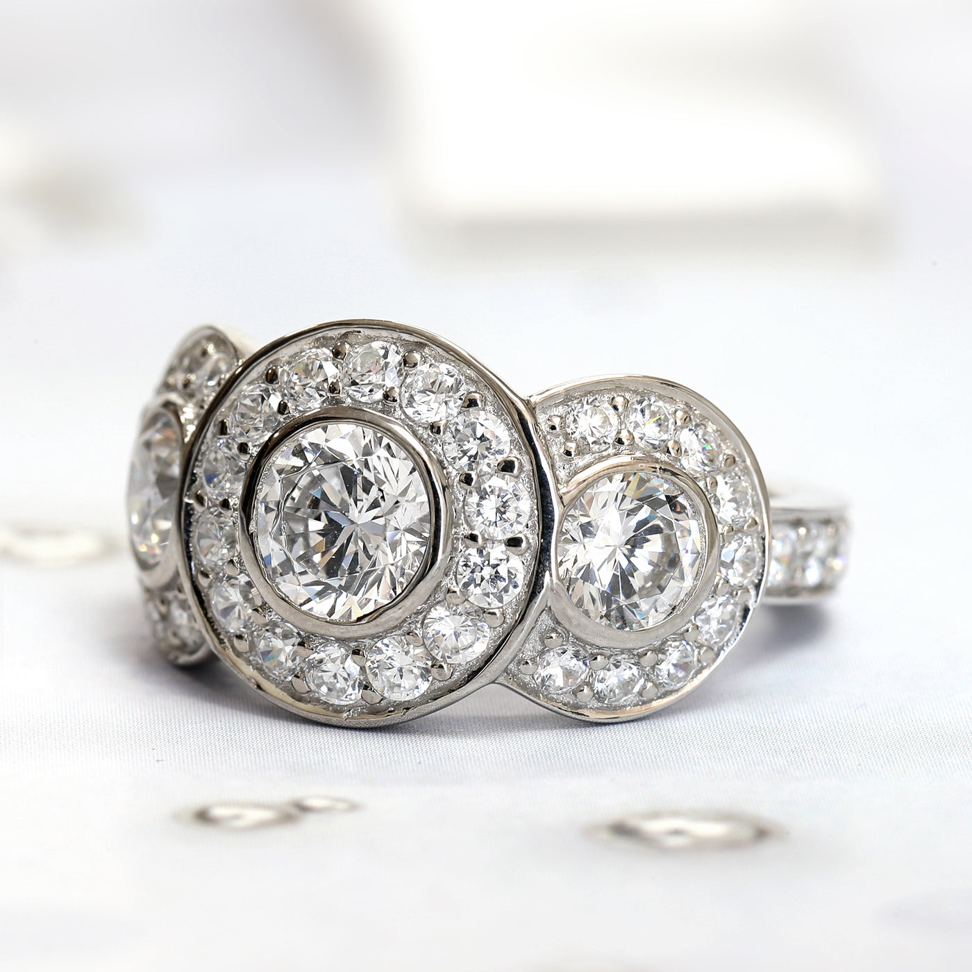 Rhodium-plated sterling silver halo trio ring with Art Deco-inspired design and cubic zirconia stones.